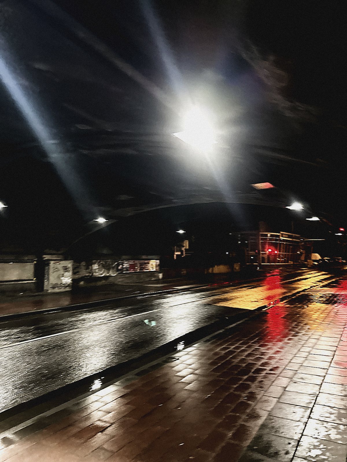 Nasse leere Straße unter Laternen