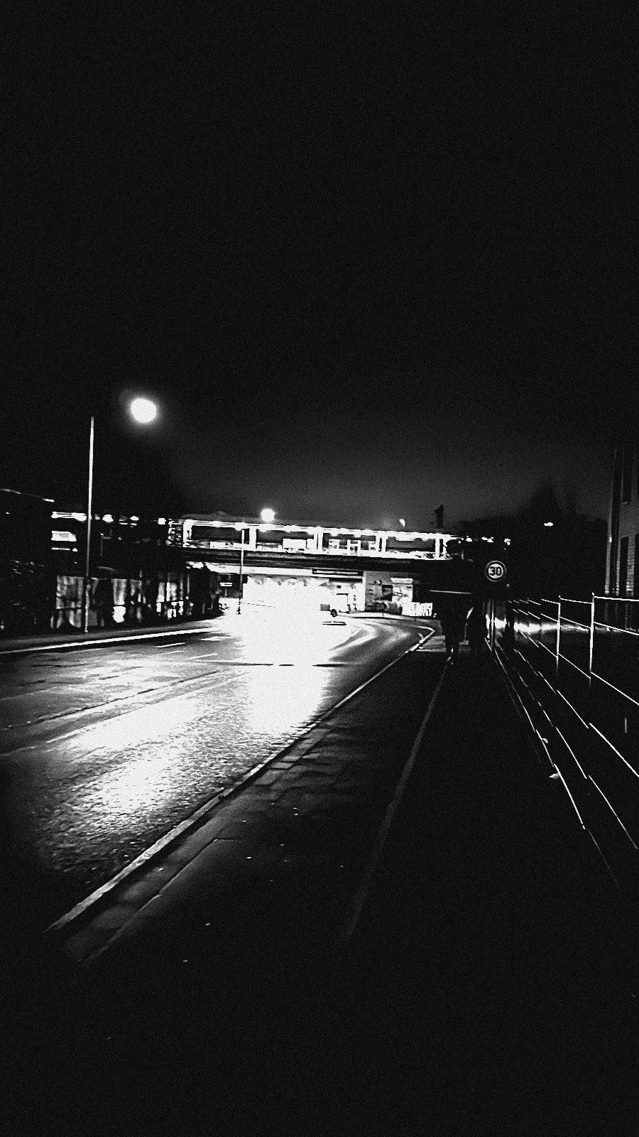 Zwei entfernte Silhouetten auf dem Heimweg unter einer Bahnbrücke