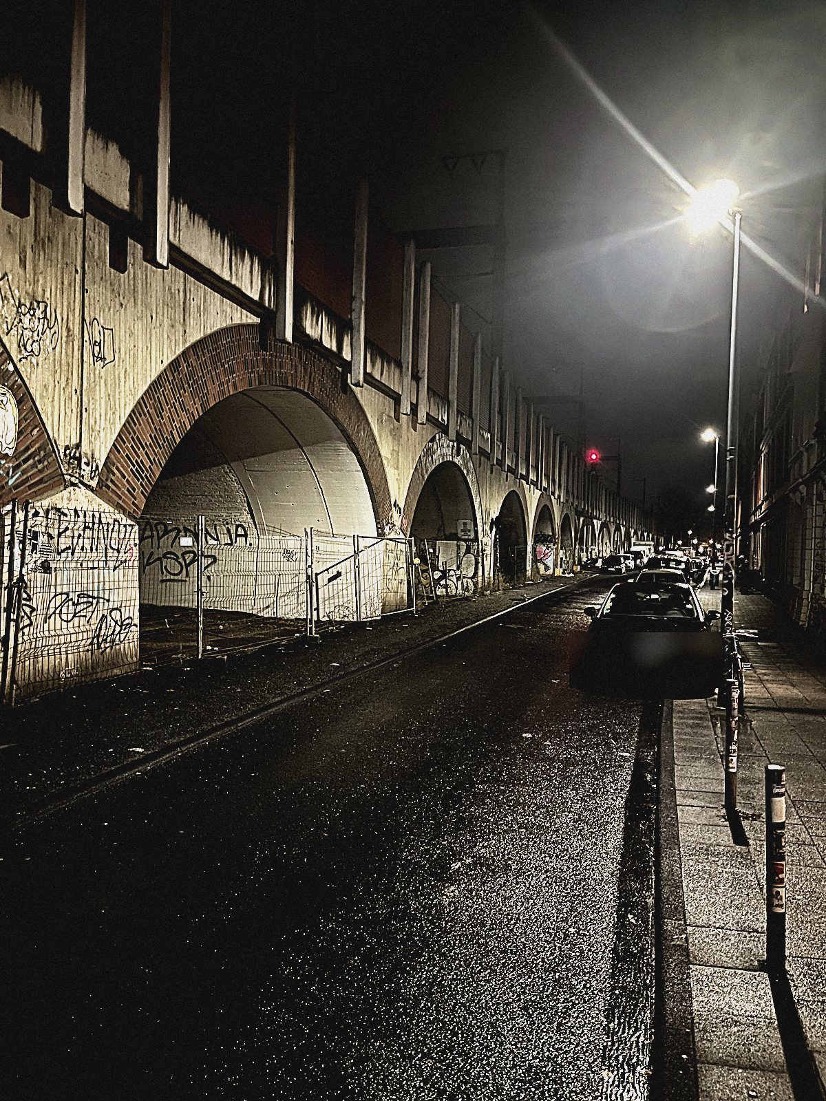 Viadukt mit parkenden Autos bei Nacht