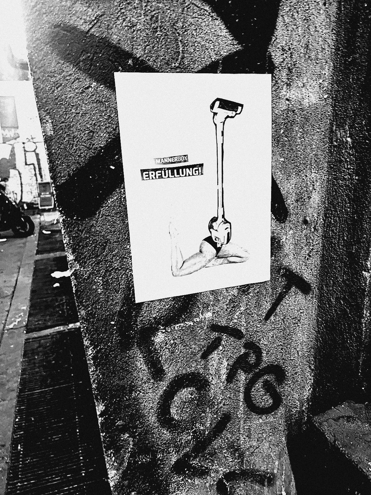 Paste-up einer Laterne neben roten Tags an Betonpfeiler