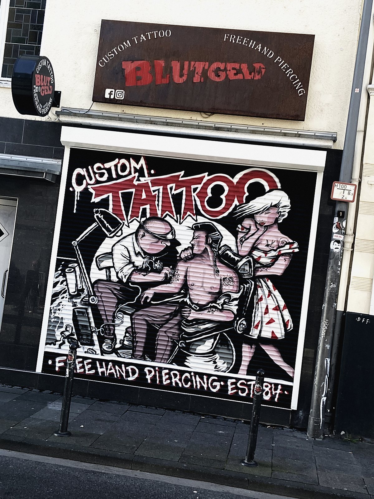Bemalter Rollladen eines Tattoo-Studios