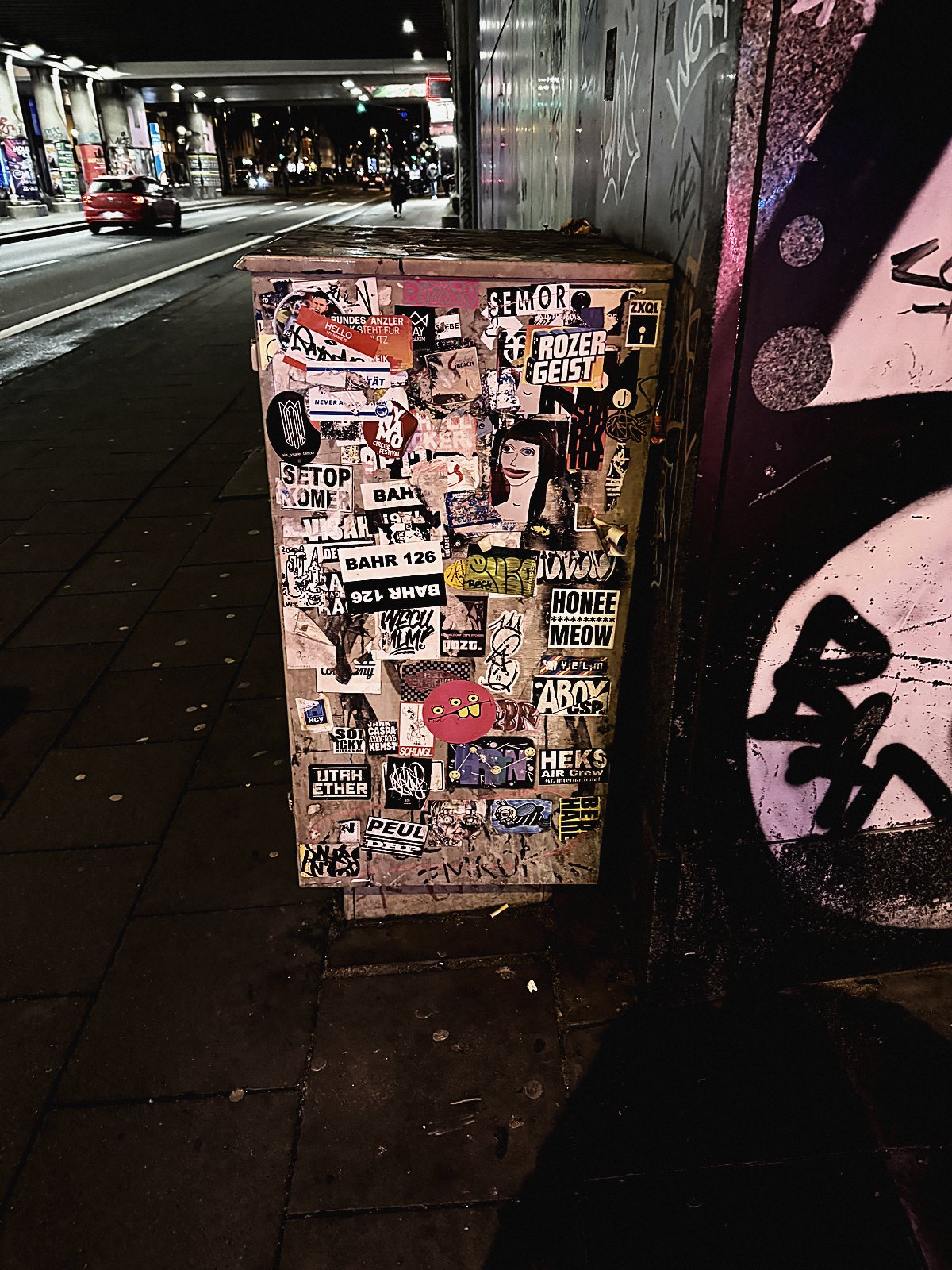 Vollständig mit Stickern beklebter Stromkasten bei Nacht am Eigelstein